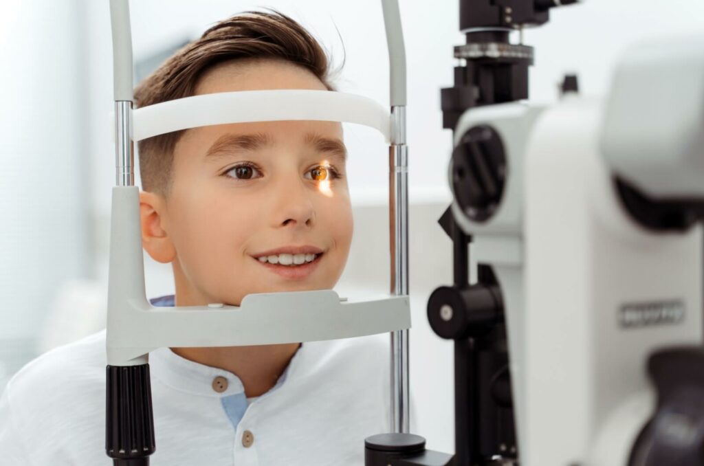 A child undergoes an eye exam using a slit lamp to determine their MiSight suitability.