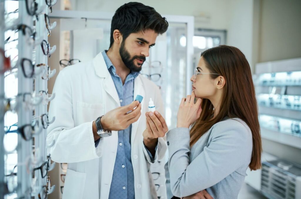 Optometrist explaining eye drops to a concerned patient