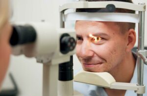 A patient has their eye examined using a slit-lamp by an optometrist.