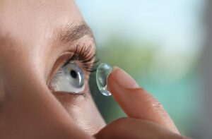 A person inserting a contact lens into their eye.