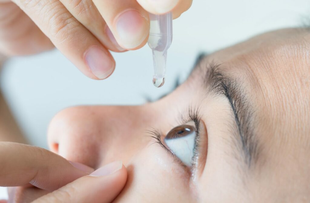 A person dropping eye drops into their eye