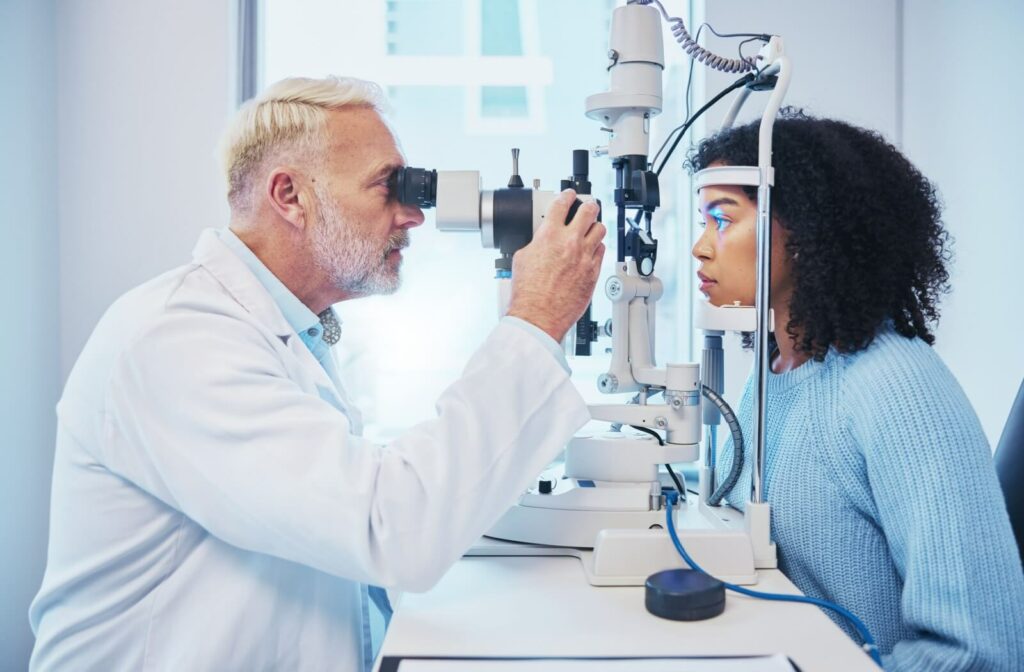 Optometrist performing an eye examination using a slit lamp to check a patient’s eye health, with the patient seated and focused straight ahead in a clinical setting.