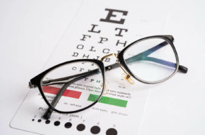 Prescription eyeglasses on an eye chart during a vision exam.