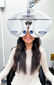 Patient undergoing a comprehensive eye exam using a phoropter.